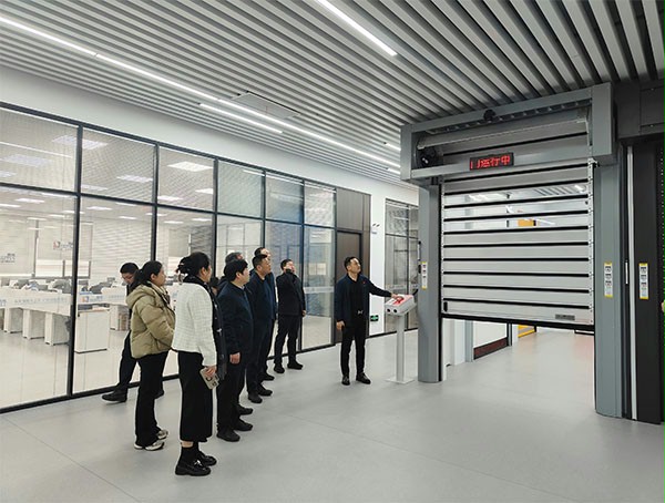 上图为：西朗门业董事长杨元嘉为领导们演示高端工业门产品在工业物联网中的应用